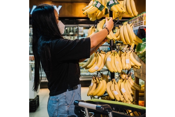 Image Woman grocery shopping for bananas.